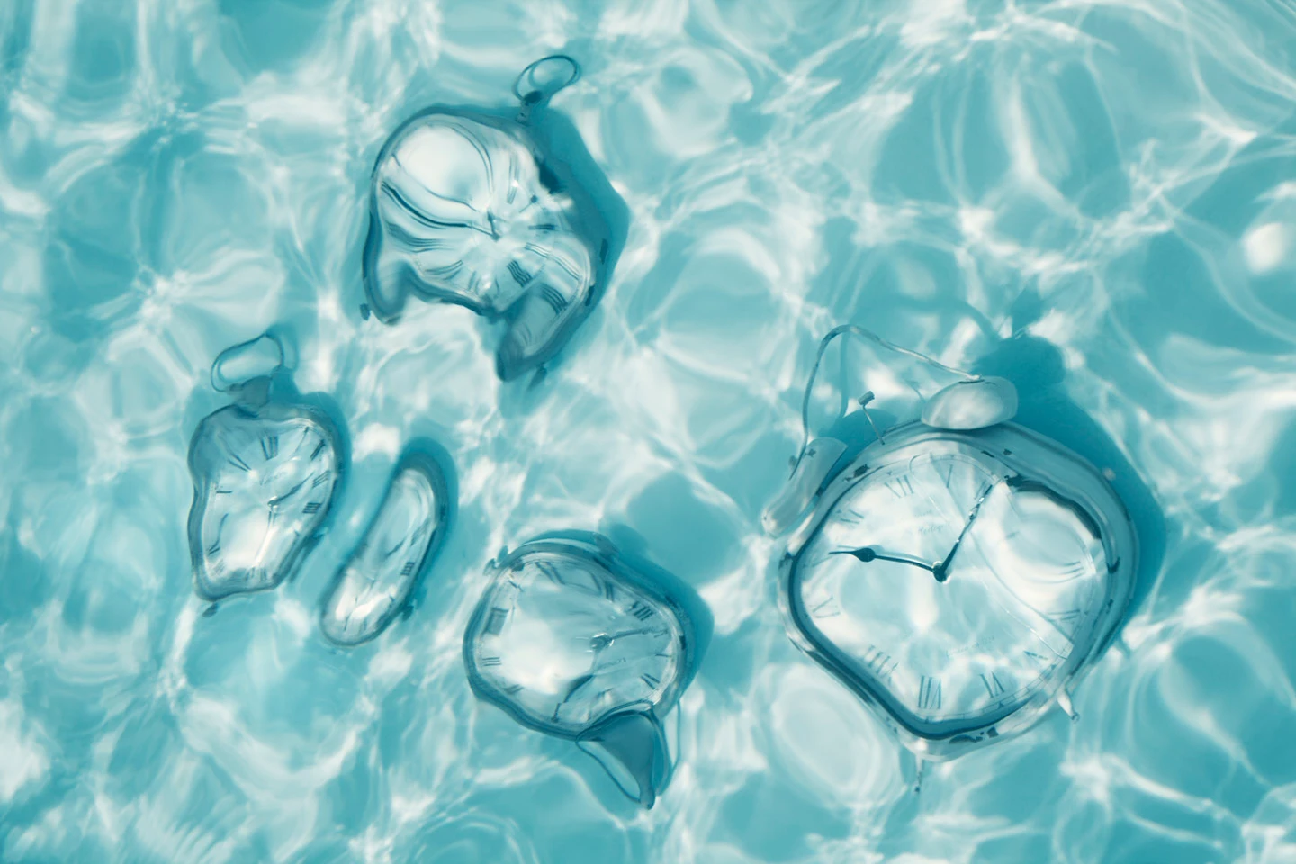 Relojes de bolsillo deformados flotando bajo el agua, luz cenital azul celeste — La Memoria del Agua, Cristina Riesgo
